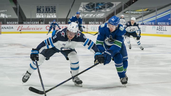 Vancouver Canucks defenceman, Quinn Hughes, battles for the puck. (Bob Frid-USA TODAY Sports)