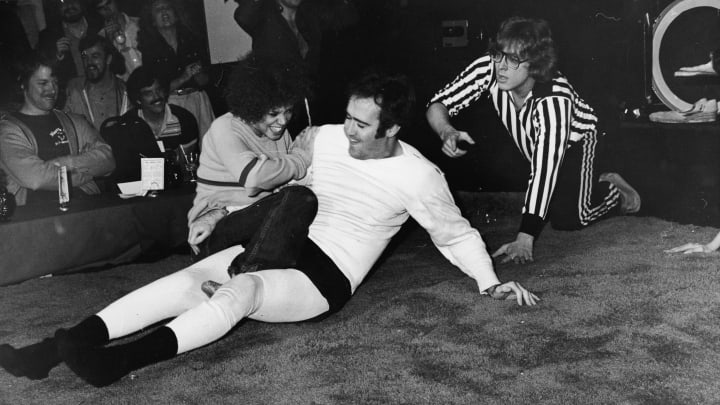 American comedian Andy Kaufman (1949 – 1984) struggles during a match against female wrestler Lena Home, as a referee looks on, Hollywood, California, December 1979. (Photo by Bob V. Noble/Fotos International/Getty Images)