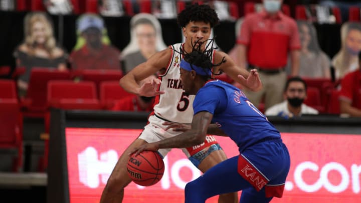 Dec 17, 2020; Lubbock, Texas, USA; Kansas Jayhawks guard Marcus Garrett (0) works the ball against Texas Tech Red Raiders guard Micah Peavy (5) in the second half at United Supermarkets Arena. Mandatory Credit: Michael C. Johnson-USA TODAY Sports