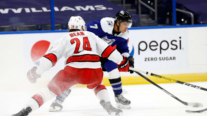 Feb 25, 2021; Tampa, Florida, USA; Tampa Bay Lightning right wing Mathieu Joseph (7) shoots as Carolina Hurricanes defenseman Jake Bean (24) defends during the third period at Amalie Arena. Mandatory Credit: Kim Klement-USA TODAY Sports