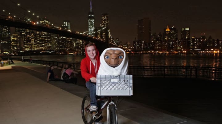NEW YORK, NY - JUNE 10: (EDITORS NOTE: This image has been altered: The moon has been digitally added and the image has been retouched) Studio artist rides E.T. figure to its new home in the film experience at Madame Tussauds New York for the anniversary of Universal Studios/Amblin Entertainment's E.T. the Extra-Terrestrial on June 10, 2014 in New York City. (Photo by Thos Robinson/Getty Images for Madame Tussauds)