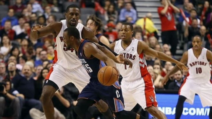 Dec 18, 2013; Toronto, Ontario, CAN; Charlotte Bobcats guard Kemba Walker (15) dribbles as Toronto Raptors forward Patrick Patterson (54) and Toronto Raptors guard Kyle Lowry (7) defend at the Air Canada Centre. Charlotte defeated Toronto 104-102 in overtime. Mandatory Credit: John E. Sokolowski-USA TODAY Sports