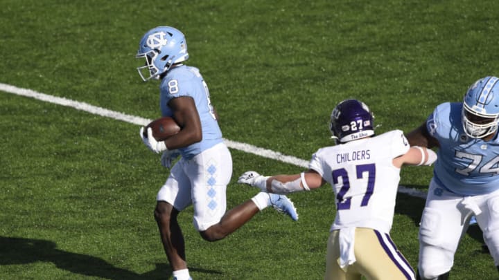 Dec 5, 2020; Chapel Hill, North Carolina, USA; North Carolina Tar Heels running back Michael Carter (8) runs for a touchdown as Western Carolina Catamounts linebacker Trevor Childers (27) defends in the second quarter at Kenan Memorial Stadium. Mandatory Credit: Bob Donnan-USA TODAY Sports