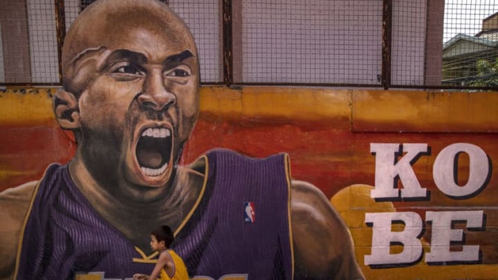 VALENZUELA, PHILIPPINES - JANUARY 28: A child poses for pictures next to a mural of former NBA star Kobe Bryant outside the "House of Kobe" basketball court on January 28, 2020 in Valenzuela, Metro Manila, Philippines. Bryant, who is hugely popular in basketball-obsessed Philippines, perished in a helicopter crash on January 26, 2020 in Calabasas, California. He died together with his 13-year-old daughter Gianna and seven others. (Photo by Ezra Acayan/Getty Images)