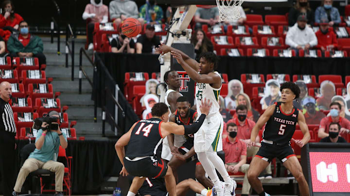 Jan 16, 2021; Lubbock, Texas, USA; Baylor Bears guard Davion Mitchell (45) passes the ball in front of Texas Tech Red Raiders forward Marcus Santos-Silva (14) in the first half at United Supermarkets Arena. Mandatory Credit: Michael C. Johnson-USA TODAY Sports