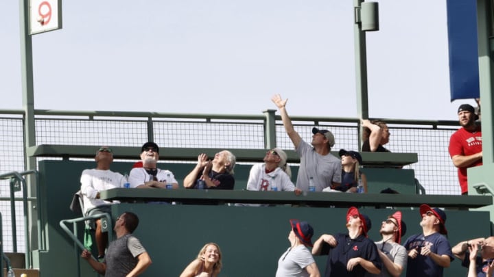 Jun 12, 2021; Boston, Massachusetts, USA; Fans in section 9 of the Green Monster seats watch as a two-run home run hit by Toronto Blue Jays designated hitter Vladimir Guerrero Jr. (not pictured) hits off the section sign during the first inning against the Boston Red Sox at Fenway Park. Mandatory Credit: Winslow Townson-USA TODAY Sports