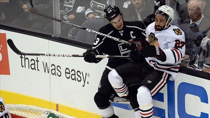 June 6, 2013; Los Angeles, CA, USA; Los Angeles Kings right wing Dustin Brown (23) hits Chicago Blackhawks defenseman Johnny Oduya (27) during the third period in game four of the Western Conference finals of the 2013 Stanley Cup Playoffs at the Staples Center. Mandatory Credit: Jayne Kamin-Oncea-USA TODAY Sports