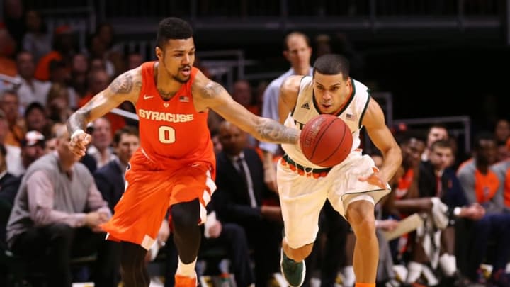 Jan 2, 2016; Coral Gables, FL, USA; Syracuse Orange forward Michael Gbinije (0) and Miami Hurricanes guard Angel Rodriguez (13) chase a loose ball during the second half at BankUnited Center. Miami won 64-51. Mandatory Credit: Steve Mitchell-USA TODAY Sports