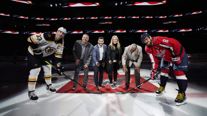 WASHINGTON, DC – DECEMBER 11: (L-R) Zdeno Chara #33 of the Boston Bruins, former NHL player Tim Thomas, former NHL player Brian Gionta, Olympian Krissy Wendell, Fort Dupont Ice Arena Founder Neal Henderson, and Alex Ovechkin #8 of the Washington Capitals take part in a ceremonial puck drop honoring the 2019 U.S. Hockey Hall of Fame Class at Capital One Arena on December 11, 2019 in Washington, DC. (Photo by Patrick McDermott/NHLI via Getty Images)