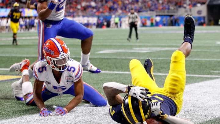 ATLANTA, GEORGIA - DECEMBER 29: Tarik Black #7 of the Michigan Wolverines drops a pass under pressure from CJ Henderson #5 of the Florida Gators in the fourth quarter during the Chick-fil-A Peach Bowl at Mercedes-Benz Stadium on December 29, 2018 in Atlanta, Georgia. (Photo by Joe Robbins/Getty Images)