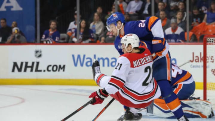 BROOKLYN, NY – APRIL 26: New York Islanders defenseman Scott Mayfield (24) stays strong in front of his net and takes down Carolina Hurricanes right wing Nino Niederreiter (21) during game one of round two of the Stanley Cup Playoffs between the New York Islanders and the Carolina Hurricanes on April 26, 2019 at the Barclays Center in Brooklyn, NY. (Photo by John McCreary/Icon Sportswire via Getty Images)