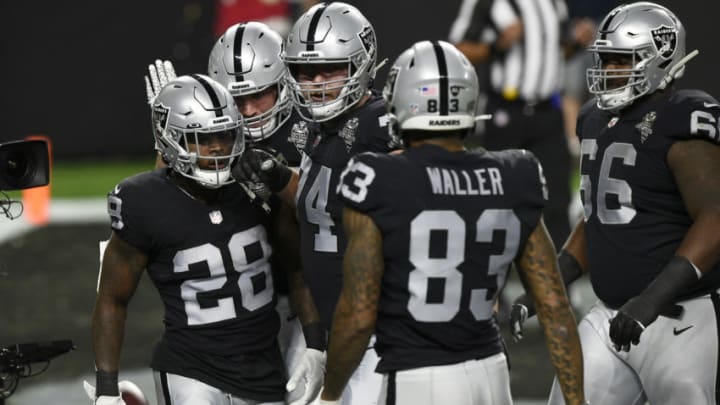 Las Vegas Raiders running back Josh Jacobs (28, left) jokes around