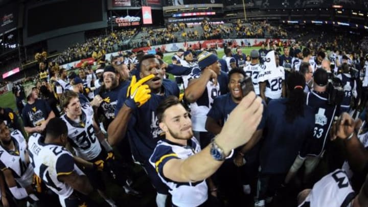 Jan 2, 2016; Phoenix, AZ, USA; West Virginia Mountaineers players celebrate after the 2016 Cactus Bowl against the Arizona State Sun Devils at Chase Field. The Mountaineers won 43-42. Mandatory Credit: Joe Camporeale-USA TODAY Sports