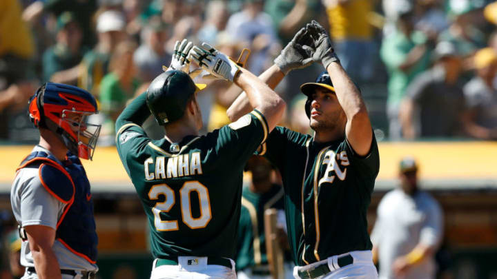OAKLAND, CA - AUGUST 05: Matt Olson #28 of the Oakland Athletics celebrates with teammate Mark Canha #20 after hitting a two-run home run in the eighth inning against the Detroit Tigers at Oakland Alameda Coliseum on August 5, 2018 in Oakland, California. (Photo by Lachlan Cunningham/Getty Images)