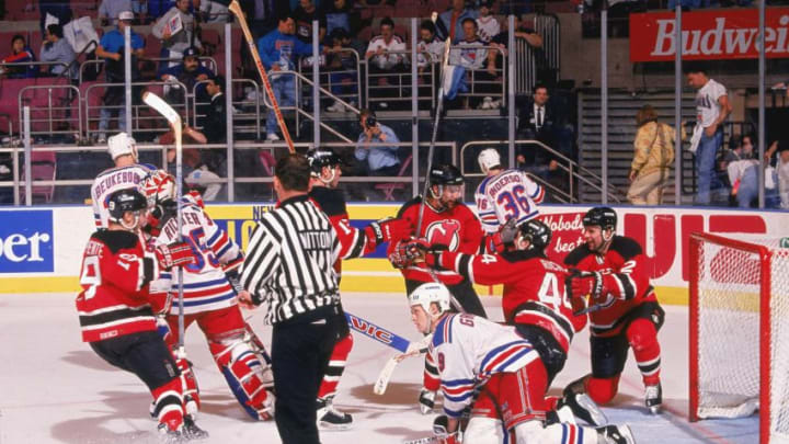 Canadian professional hockey player Stephane Richer (kneeling, #44), left wing for the New Jersey Devils, celebrates double overtime in front of the goal during Game 1 of the Eastern Conference Finals with the New York Rangers at Madison Square Garden, New York, New York, May 15, 1994. Devils teammates nearby include Russian-born professional hockey player Viacheslav Fetisov (right), Canadian hockey player Scott Niedermayer (center with beard), and American hockey player Bobby Carpenter (left). New York Rangers players nearby are Canadian professional hockey player and defenseman Jeff Beukeboom, American goalie Mike Richter, Canadian left wing Adam Graves, and Canadian forward Glenn Anderson. (Photo by Brian Winkler/Getty Images)