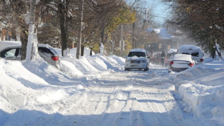 Buffalo, NY - November 20: Cars make their way through tree lined streets after an intense lake-effect snowstorm that impacted the area on November 20, 2022 in Buffalo, New York. Around Buffalo and the surrounding suburbs, the snowstorm resulted in up to six feet of accumulation and has been attributed to at least three deaths. The band of snow is expected to weaken overnight with milder temperatures expected. (Photo by John Normile/Getty Images)