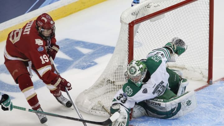 Apr 7, 2016; Tampa, FL, USA; North Dakota Fighting Hawks goalie Cam Johnson (33) blocks a shot from Denver Pioneers forward Troy Terry (19) during the second period of the semifinals of the 2016 Frozen Four college ice hockey tournament at Amalie Arena. Mandatory Credit: Reinhold Matay-USA TODAY Sports