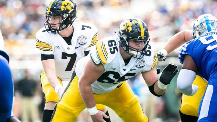 Iowa quarterback Spencer Petras (7) takes a snap from center Tyler Linderbaum (65) during a NCAA college football game in the Vrbo Citrus Bowl against Kentucky, Saturday, Jan. 1, 2022, at Camping World Stadium in Orlando, Fla.220101 Iowa Kentucky Citrus Fb Extra 043 Jpg