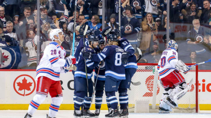 WINNIPEG, MB - FEBRUARY 12: Chris Kreider #20 of the New York Rangers skates away as Winnipeg Jets players celebrate a first period goal by Mark Scheifele #55 at the Bell MTS Place on February 12, 2019 in Winnipeg, Manitoba, Canada. (Photo by Jonathan Kozub/NHLI via Getty Images)