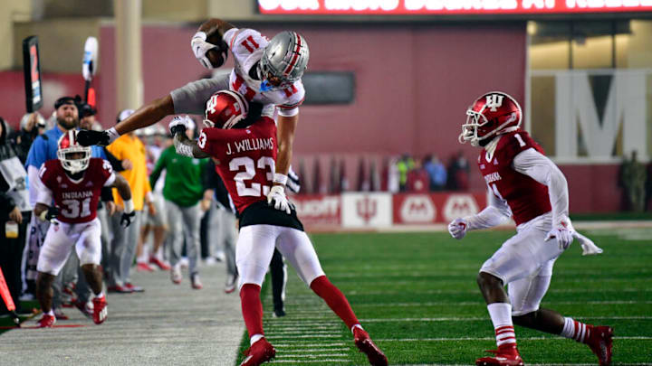 Oct 23, 2021; Bloomington, Indiana, USA; Ohio Ohio State Buckeyes wide receiver Jaxon Smith-Njigba (11) tries to jump over Indiana Hoosiers defensive back Jaylin Williams (23) during the second quarter at Memorial Stadium. Mandatory Credit: Marc Lebryk-USA TODAY Sports
