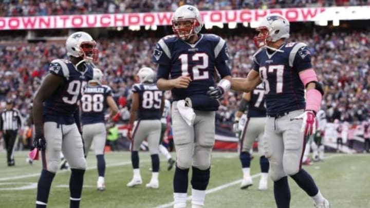 Oct 25, 2015; Foxborough, MA, USA; New England Patriots quarterback Tom Brady (12) celebrates with defensive end Chandler Jones (95) and tight end Rob Gronkowski (87) after throwing a touchdown pass during the fourth quarter against the New York Jets at Gillette Stadium. The New England Patriots won 30-23. Mandatory Credit: Greg M. Cooper-USA TODAY Sports