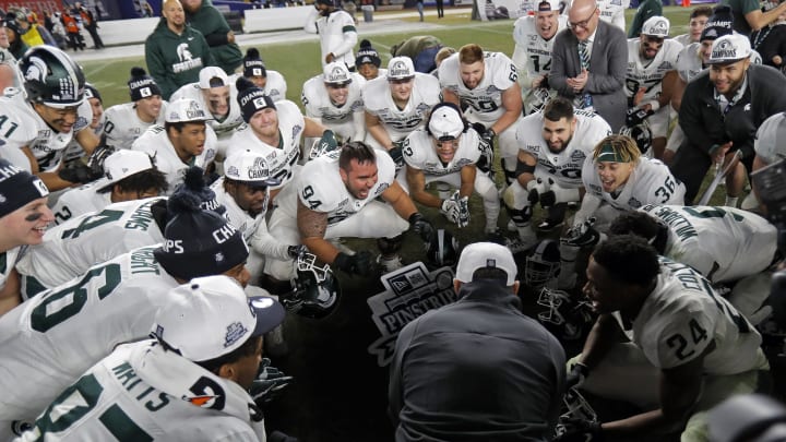 NEW YORK, NY – DECEMBER 27: Head coach Mark Dantonio of the Michigan State Spartans (gray coat) celebrates with his players after defeating the Wake Forest Demon Deacons in the New Era Pinstripe Bowl at Yankee Stadium on December 27, 2019 in the Bronx borough of New York City. Michigan State Spartans won 27-21. (Photo by Adam Hunger/Getty Images)