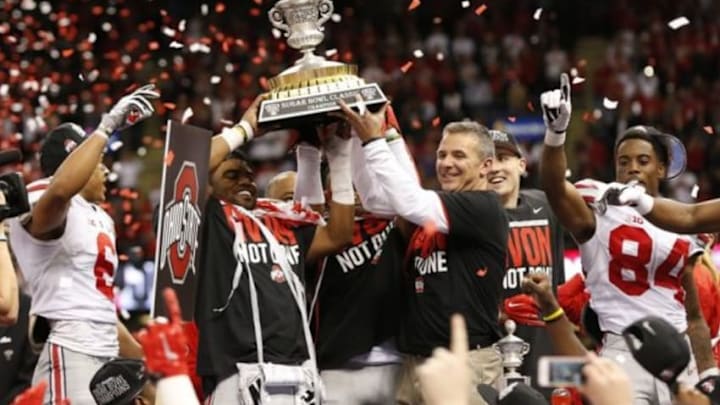 Jan 1, 2015; New Orleans, LA, USA; Ohio State Buckeyes head coach Urban Meyer hoists the Sugar Bowl Trophy with running back Ezekiel Elliott (left) after the game against the Alabama Crimson Tide in the 2015 Sugar Bowl at Mercedes-Benz Superdome. The Buckeyes beat the Crimson Tide 42-35. Mandatory Credit: Matthew Emmons-USA TODAY Sports