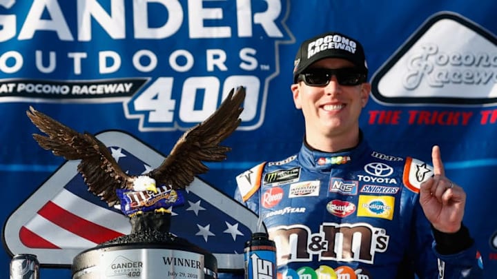 LONG POND, PA - JULY 29: Kyle Busch, driver of the #18 M&M's Caramel Toyota, poses with the trophy in Victory Lane after winning the Monster Energy NASCAR Cup Series Gander Outdoors 400 at Pocono Raceway on July 29, 2018 in Long Pond, Pennsylvania. (Photo by Jeff Zelevansky/Getty Images)