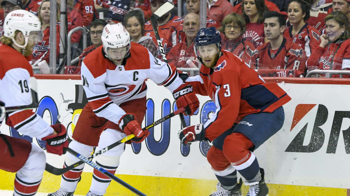WASHINGTON, DC – APRIL 20: Carolina Hurricanes right wing Justin Williams (14) and Washington Capitals defenseman Nick Jensen (3) fight for a loose puck in the first period on April 20, 2019, at the Capital One Arena in Washington, D.C. in the first round of the Stanley Cup Playoffs. (Photo by Mark Goldman/Icon Sportswire via Getty Images)
