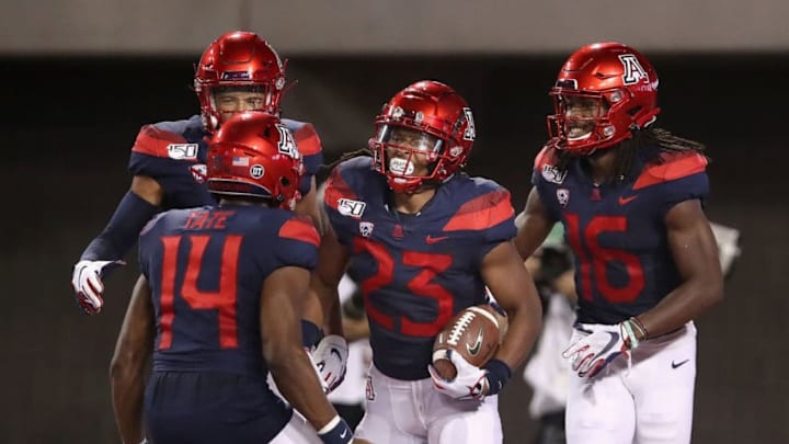TUCSON, ARIZONA - SEPTEMBER 07: Running back Gary Brightwell #23 of the Arizona Wildcats celebrates with Khalil Tate #14 and Thomas Reid III #16 after scoring on a 94 yard rushing touchdown against the Northern Arizona Lumberjacks during the first half of the NCAAF game at Arizona Stadium on September 07, 2019 in Tucson, Arizona. (Photo by Christian Petersen/Getty Images)