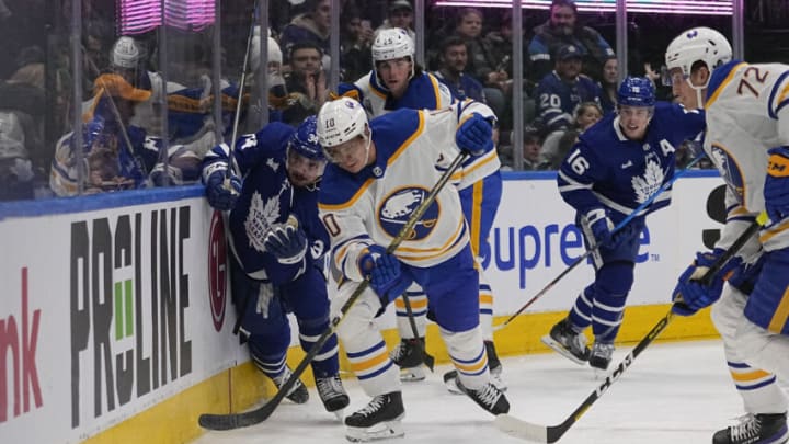 Mar 13, 2023; Toronto, Ontario, CAN; Buffalo Sabres defenseman Henri Jokiharju (10) battles with Toronto Maple Leafs forward Auston Matthews (34) for the puck during the first period at Scotiabank Arena. Mandatory Credit: John E. Sokolowski-USA TODAY Sports