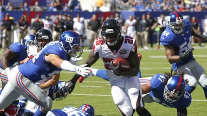 Sep 20, 2015; East Rutherford, NJ, USA; Atlanta Falcons running back Tevin Coleman (26) runs by New York Giants outside linebacker Mark Herzlich (94) and New York Giants middle linebacker Uani