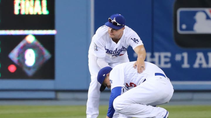 LOS ANGELES, CA - APRIL 25: Los Angeles Dodgers left fielder Joc Pederson (31) helps us Los Angeles Dodgers shortstop Corey Seager (5) after Seager appears to him himself following an awkward fall while trying to catch a shallow bloop single in the game between the Miami Marlins and Los Angeles Dodgers on April 25, 2018, at Dodger Stadium in Los Angeles, CA. (Photo by Peter Joneleit/Icon Sportswire via Getty Images)