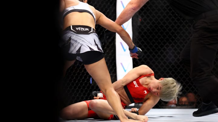 SINGAPORE, SINGAPORE - JUNE 12: Silvana Gomez Juarez (L) of Argentina knocks out Liang Na of China in their strawweight bout during UFC 275 at Singapore Indoor Stadium on June 12, 2022 in Singapore. (Photo by Yong Teck Lim/Getty Images)