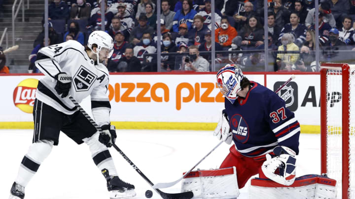 Apr. 2, 2022; Winnipeg, Manitoba, CAN; Winnipeg Jets goaltender Connor Hellebuyck (37) blocks a shot by Los Angeles Kings center Phillip Danault (24) in the first period at Canada Life Centre. Mandatory Credit: James Carey Lauder-USA TODAY Sports