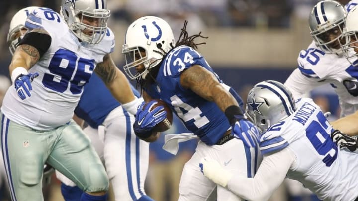 Dec 21, 2014; Arlington, TX, USA; Indianapolis Colts running back Trent Richardson (34) carries the ball as Dallas Cowboys defensive end Jeremy Mincey (92) and defensive tackle Nick Hayden (96) defend in the first quarter at AT&T Stadium. Mandatory Credit: Tim Heitman-USA TODAY Sports