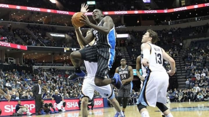 Dec 9, 2013; Memphis, TN, USA; Orlando Magic guard Victor Oladipo (5) drives to the basket defended by Memphis Grizzlies forward Jon Leuer (30) and guard Mike Miller (13) during the first half at FedExForum. Mandatory Credit: Nelson Chenault-USA TODAY Sports