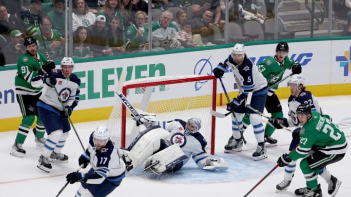DALLAS, TEXAS - OCTOBER 17: Connor Hellebuyck #37 of the Winnipeg Jets gets upended while defending a shot on goal against the Dallas Stars in the third period at American Airlines Center on October 17, 2022 in Dallas, Texas. (Photo by Tom Pennington/Getty Images)