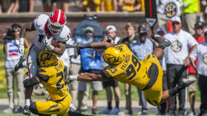 Georgia Bulldogs running back Elijah Holyfield (13) attempts to break the tackles of Missouri Tigers defensive back Khalil Oliver (20) and Missouri Tigers defensive lineman Walter Palmore (99)  (Photo by Nick Tre. Smith/Icon Sportswire via Getty Images)