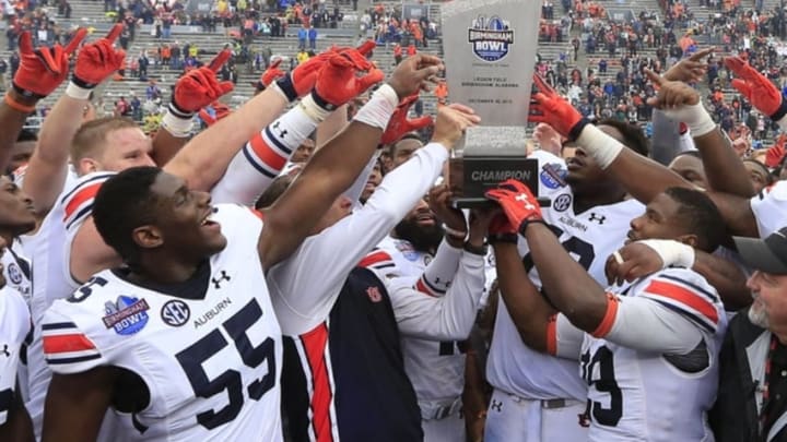 Dec 30, 2015; Birmingham, AL, USA; Auburn Tigers head coach Gus Malzahn along with his team hold up the Birmingham Bowl trophy after they defeated Memphis Tigers 31-10 in the 2015 Birmingham Bowl at Legion Field. Mandatory Credit: Marvin Gentry-USA TODAY Sports