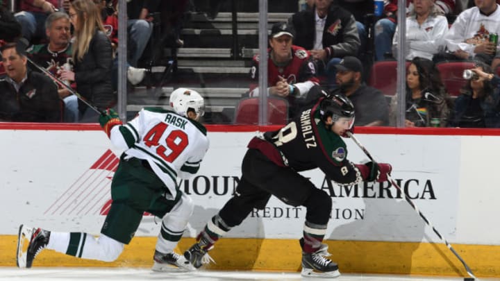 GLENDALE, ARIZONA - NOVEMBER 09: Nick Schmaltz #8 of the Arizona Coyotes skates the puck along the boards while being defended by Victor Rask #49 of the Minnesota Wild at Gila River Arena on November 09, 2019 in Glendale, Arizona. (Photo by Norm Hall/NHLI via Getty Images)