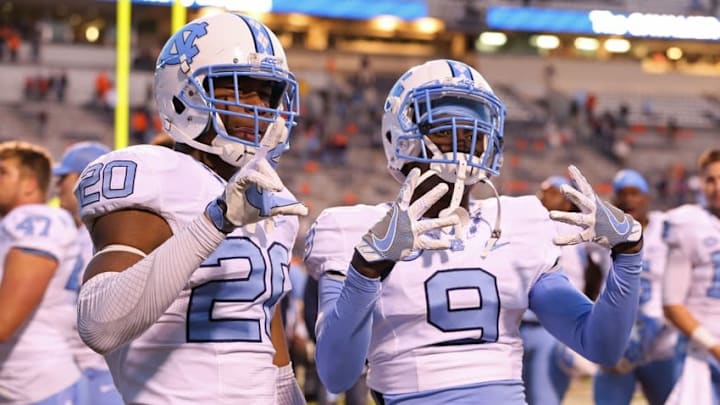 Oct 22, 2016; Charlottesville, VA, USA; North Carolina Tar Heels linebacker Dominique Ross (20) and Tar Heels defensive back K.J. Sails (9) celebrate after their game against the Virginia Cavaliers at Scott Stadium. The Tar Heels won 35-14. Mandatory Credit: Amber Searls-USA TODAY Sports