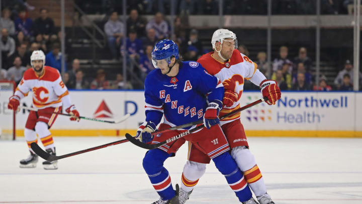 Oct 25, 2021; New York, New York, USA; New York Rangers defenseman Jacob Trouba (8) and Calgary Flames center Trevor Lewis (22) battle for a puck during the first period at Madison Square Garden. Mandatory Credit: Danny Wild-USA TODAY Sports