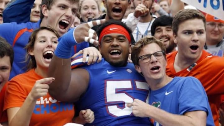 Nov 22, 2014; Gainesville, FL, USA; Florida Gators defensive lineman Caleb Brantley (57) jumps into the stands with fans after they beat the Eastern Kentucky Colonels at Ben Hill Griffin Stadium. Florida Gators defeated the Eastern Kentucky Colonels 52-3. Mandatory Credit: Kim Klement-USA TODAY Sports