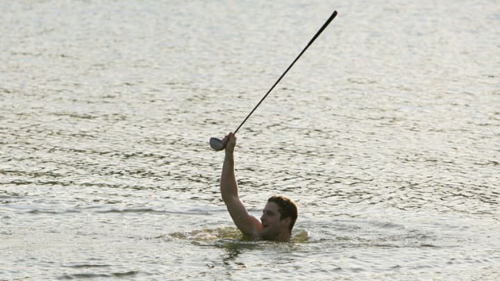 PONTE VEDRA BEACH, FL - MARCH 24: Golf fan Kelly Shields retrieves Woody Austin's driver from the lake after Austin threw it in from the 18th tee during the first round of The Players Championship at the TPC at Sawgrass March 24, 2005 in Ponte Vedra Beach, Florida. (Photo by Richard Heathcote/Getty Images)