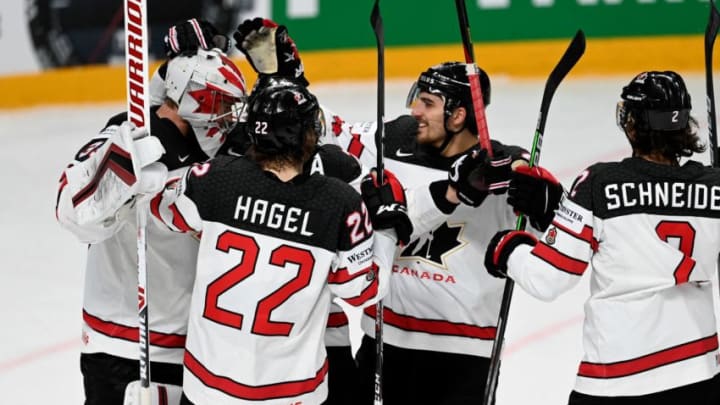 Canada's goalkeeper Darcy Kuemper (L) is celebrated by teammates including New York Rangers prospect Braden Schneider. (Photo by Gints IVUSKANS / AFP) (Photo by GINTS IVUSKANS/AFP via Getty Images)
