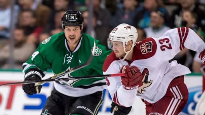 Nov 20, 2014; Dallas, TX, USA; Dallas Stars left wing Jamie Benn (14) and Arizona Coyotes defenseman Oliver Ekman-Larsson (23) chase the puck during the third period at the American Airlines Center. The Stars defeated the the Coyotes 3-1. Mandatory Credit: Jerome Miron-USA TODAY Sports