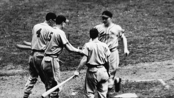NEW YORK – OCTOBER 5: Whitey Kurowski #1 (1918 – 1999) of the St. Louis Cardinals runs across home plate after hitting a home run as his teammates Marty Marion #4 and Walker Cooper #15 congratulate him during game five of the 1942 World Series against the New York Yankees at Yankee Stadium, in the Bronx, New York on October 5, 1942. The Cardinals won game five 4-2 and wrapped up the series. (Photo by Hulton Archive/Getty Images)