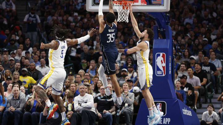 Christian Wood of the Dallas Mavericks drives to the basket against Kevon Looney and Klay Thompson of the Golden State Warriors at American Airlines Center on March 22, 2023. (Photo by Tim Heitman/Getty Images)