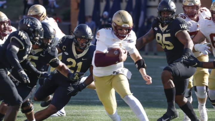 Oct 22, 2022; Winston-Salem, North Carolina, USA; Boston College Eagles quarterback Phil Jurkovec (5) runs with the ball between Wake Forest Demon Deacons linebacker Chase Jones (21) and defensive lineman Dion Bergan Jr. (95) during the first quarter at Truist Field. Mandatory Credit: Reinhold Matay-USA TODAY Sports